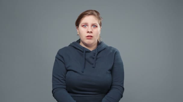 Sweatshirt giymiş korkmuş şişman bir kadının videosu. - Video, Çekim