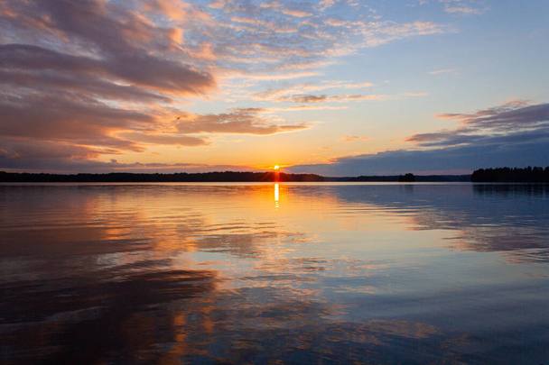 Amazing view of the sunset, lake and sky, gorgeous sky and reflection in the water - 写真・画像