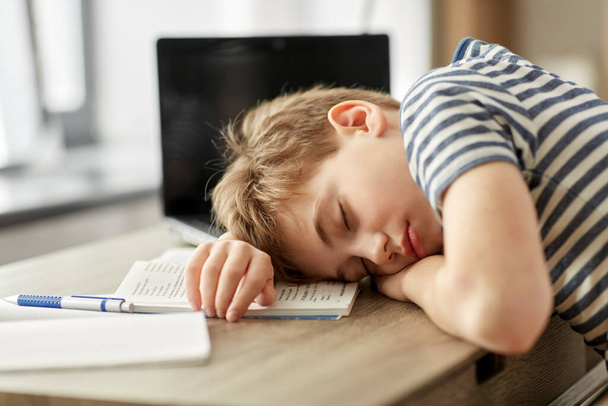 tired student boy sleeping on desk at home - Фото, изображение