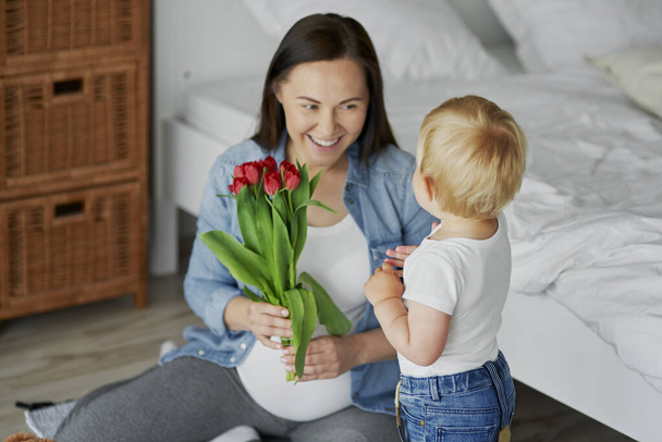 Batole chlapec dává své mámě hromadu tulipánů - Fotografie, Obrázek