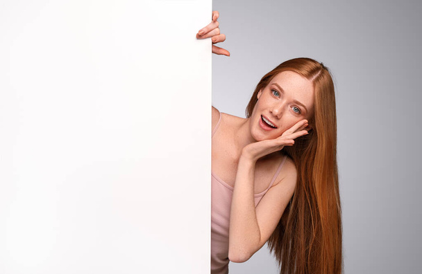 Happy redhead woman advertising spa service - Photo, Image