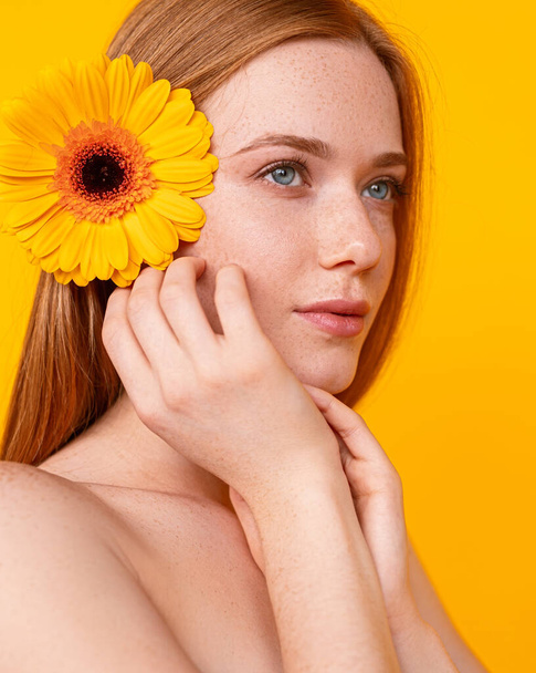 Redhead female with flower in hair - Foto, imagen