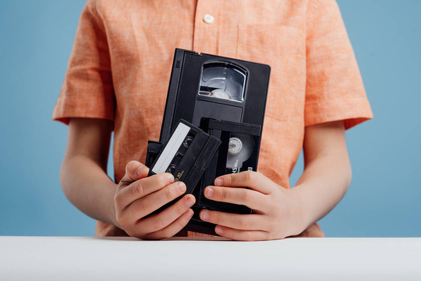 close up, video tape in child hand, isolated on blue background, - Zdjęcie, obraz