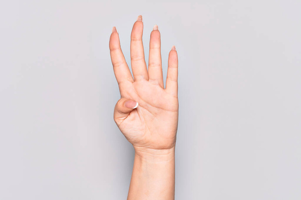 Hand of caucasian young woman counting number 4 showing four fingers - Photo, Image