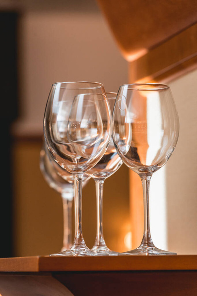 Leere Weingläser auf dem Holztisch spiegeln sich im Glas - Foto, Bild