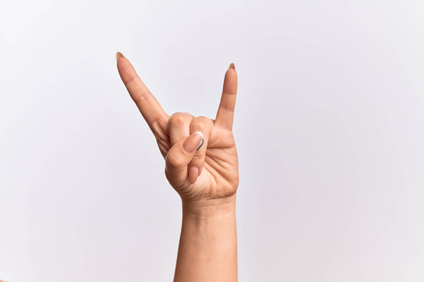 Käsi valkoihoinen nuori nainen elehtii rock and roll symboli, osoittaa säädytön sarvet ele - Valokuva, kuva