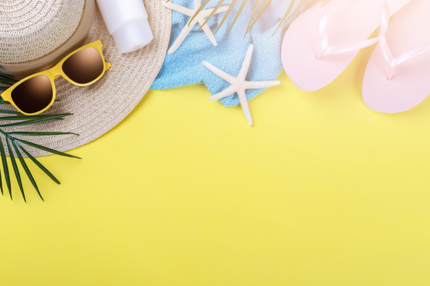 Accesorios de playa sobre fondo amarillo, gafas de sol, protector solar, chanclas, toalla y sombrero, concepto de vacaciones de verano, espacio para copiar
 - Foto, imagen