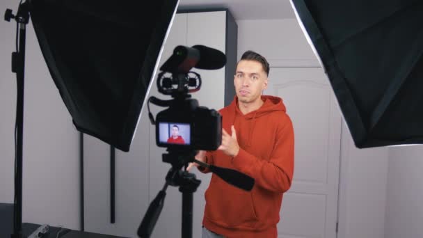 Giovane blogger uomo riprese nuovo video vlog con fotocamera professionale a casa
 - Filmati, video