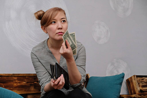 Das Mädchen hält zwei Scheine mit einem Nennwert von einem US-Dollar in der Hand. - Foto, Bild