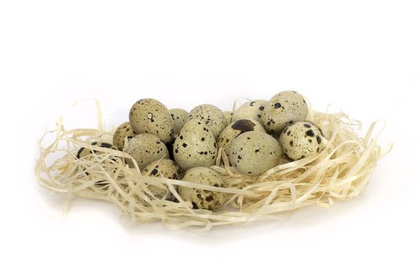 De nombreux œufs de caille tachetés dans le nid de paille. Isolé sur fond blanc. Vue latérale
 - Photo, image