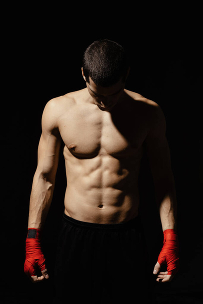 Boxeador atlético preparándose antes de la pelea sobre fondo negro
 - Foto, imagen