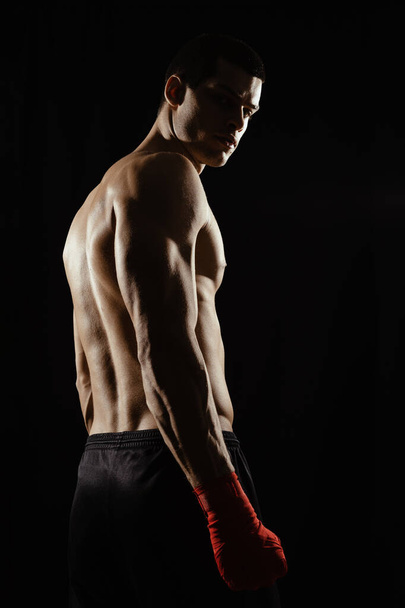 Portrait of male boxer looking over shoulder - Photo, Image