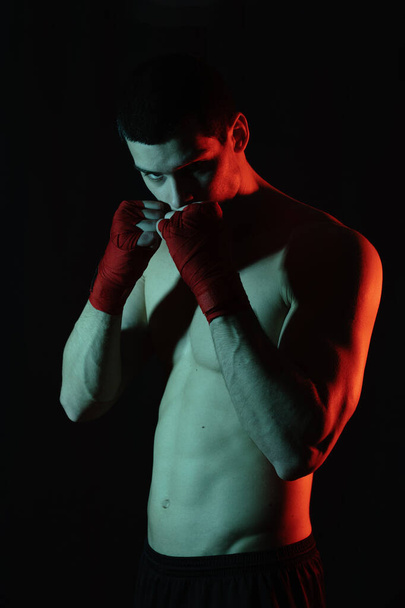 Boxeador luchador masculino posando en postura defensiva segura con las manos en banndages hasta
 - Foto, imagen
