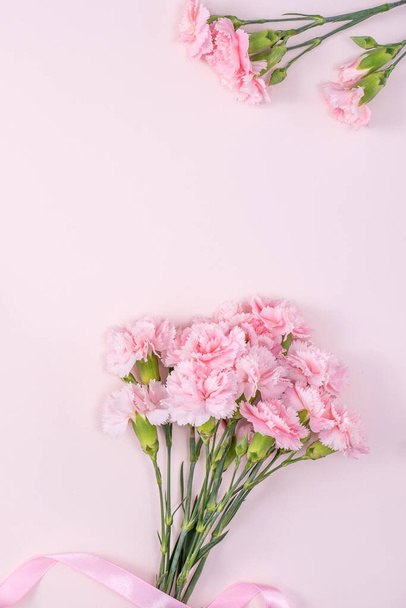 Ημέρα της μητέρας, Ημέρα του Αγίου Βαλεντίνου έννοια σχεδιασμού φόντου, όμορφο ροζ λουλούδι γαρύφαλλο μπουκέτο σε παστέλ ροζ τραπέζι, top view, επίπεδη lay, αντίγραφο χώρου. - Φωτογραφία, εικόνα