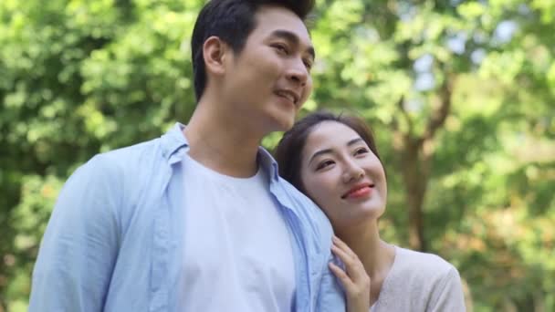 幸せな若いアジアの恋人カップルリラックス屋外で公園 - 映像、動画