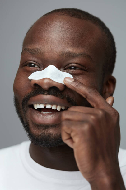 Skin Care. Beauty Treatment Concept. Man Applying White Nose Patch. Closeup Of Pore Cleansing Strips For Facecare. - Foto, immagini