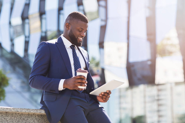 Pozytywne Businessman Korzystanie z tabletu podczas przerwy na kawę w mieście - Zdjęcie, obraz