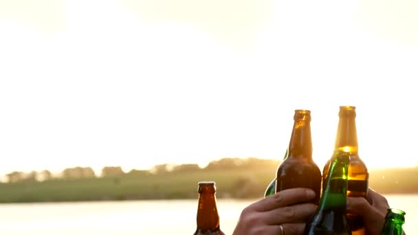Szczęśliwi przyjaciele tańczący o zachodzie słońca z drinkiem w rękach - Materiał filmowy, wideo