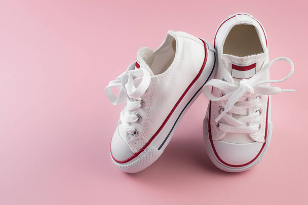 Photo of white sneakers over pink background. - Photo, Image