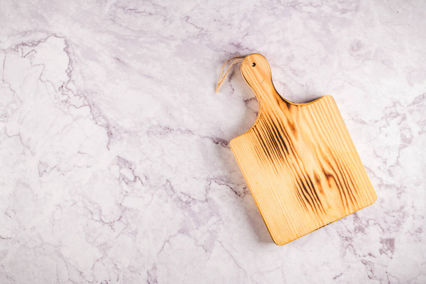 Top view of wooden cutting board on a gray marble background with space for text. - 写真・画像