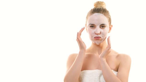 Atraktivní žena s čistou maskou dotýkající se obličeje na bílém pozadí - Záběry, video