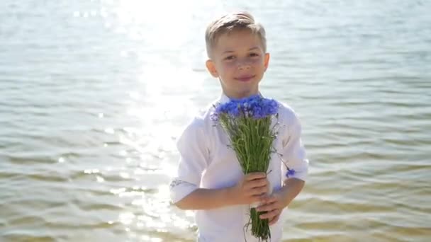 Leuke en mooie jongen, een kind met een boeket bloemen. 8 maart, internationale vrouwendag, moeder-, moeder- en zoondag. Bloemengeschenk - Video