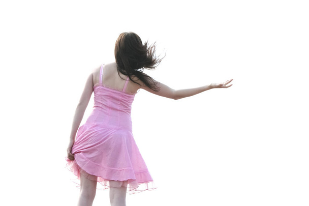 dancing brunette girl in short transparent pink dress  on her sexy legs isolated on white background - Фото, зображення