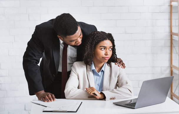 Molestowanie w miejscu pracy. Młoda Afroamerykanka nękana przez swojego pożądliwego szefa. Panorama - Zdjęcie, obraz
