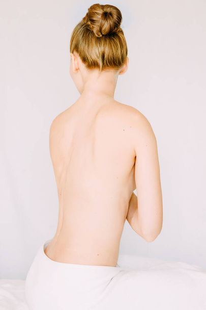 Πίσω όψη της γυναίκας φορώντας πετσέτα, Όμορφη νεαρή γυναίκα προετοιμάσει το σώμα της για το ντους, spa ή μασάζ - Φωτογραφία, εικόνα