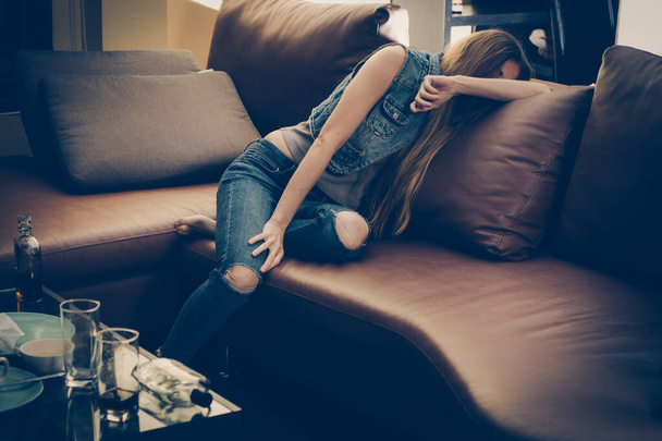 Νεαρή μεθυσμένη γυναίκα στον καναπέ. Κατάθλιψη. Ανθυγιεινός τρόπος ζωής. - Φωτογραφία, εικόνα