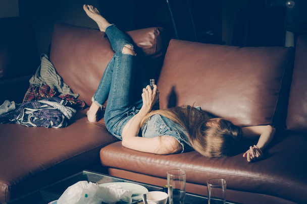 Young drunk woman on the sofa. Depression concept. Unhealthy lifestyle. - Foto, afbeelding