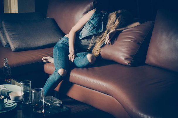 ソファの上の若い酔った女性。うつ病の概念。不健康な生活様式. - 写真・画像