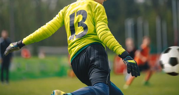 Goal kick by soccer junior level goalie. Football goalkeeper kick during competition match - Foto, afbeelding