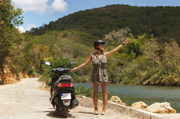 Young woman traveler and  scooter on old rural road in the mountains - Φωτογραφία, εικόνα