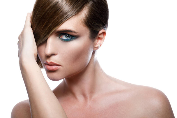 Model in stylish image with sleek hair covering one eye and beautiful green eyeshadows on another - Foto, Bild