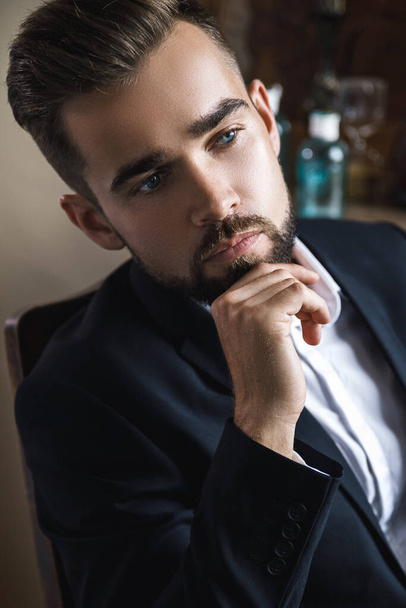 Portrait of handsome bearded man wearing black classic suit - Photo, Image