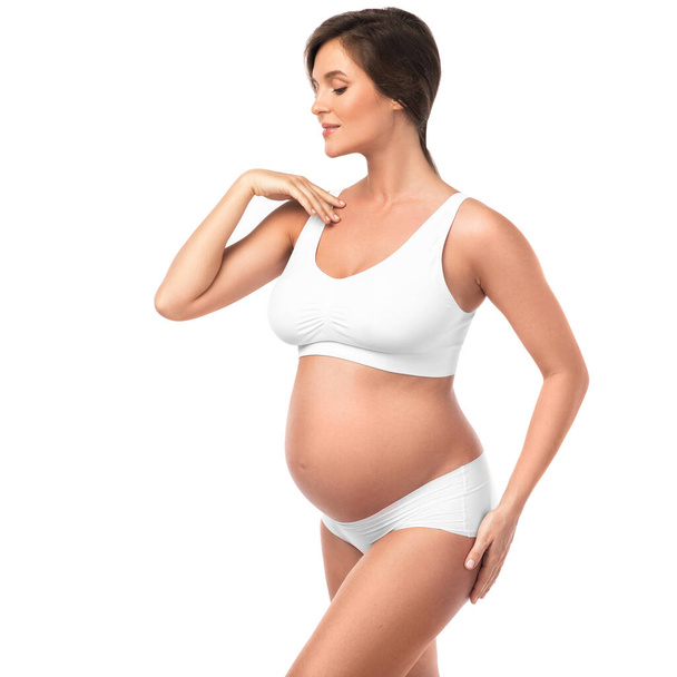 Young and beautiful pregnant woman wearing lingerie on white background - Foto, immagini