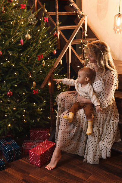 Young happy mother and her cute little son are celebrating Christmas or New year. - Photo, Image
