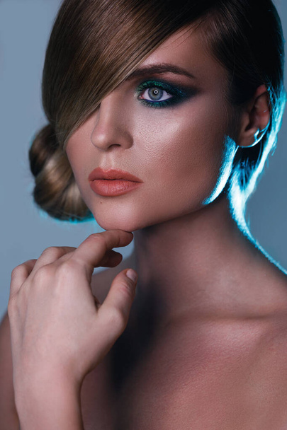 Model in stylish image with sleek hair covering one eye and beautiful green eyeshadows on another - Foto, Imagem
