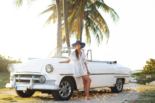 Happy young woman and retro convertible car beside the beach at Varadero city - 写真・画像