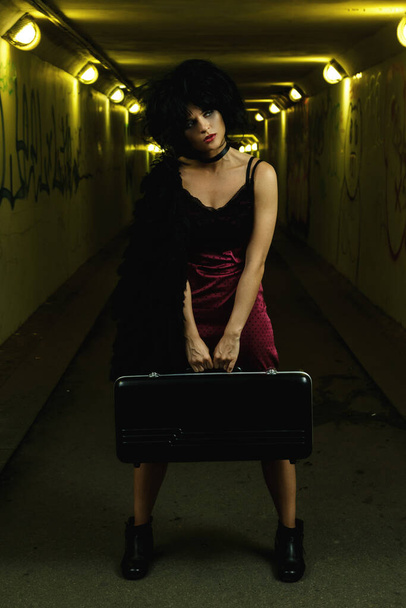 Strange and freaky woman with a disheveled hair in the dark tunnel - Фото, изображение