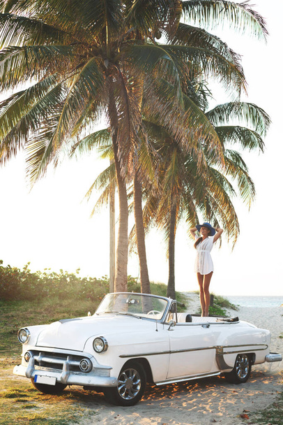 Happy young woman and retro convertible car beside the beach at Varadero city - Photo, Image