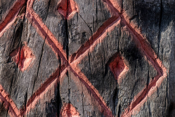 スラブの異教の密教のシンボル(ルーン)は、亀裂と、燃焼の痕跡を持つ木に刻まれています. - 写真・画像