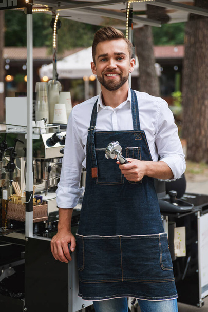 Handsome barista man during work in his movable street coffee shop - Photo, image