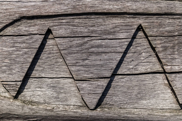 Una fila di triangoli grandi intagliati con noncuranza su un albero crepato e secco
 - Foto, immagini