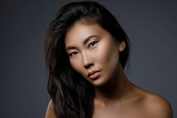 Portrait of beautiful asian woman with a black healthy hair - Фото, зображення