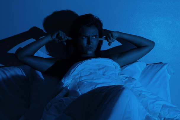 Woman with insomnia because of loud noises in the bedroom - Photo, image