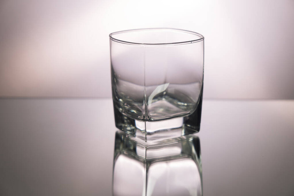 Aynalı masada bir bardak viski. Kopya alanı ile görsel görüntü. Gri arkaplan - Fotoğraf, Görsel