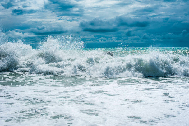 Storm waves on the ocean against a turquoise sky and clouds. Surf - 写真・画像