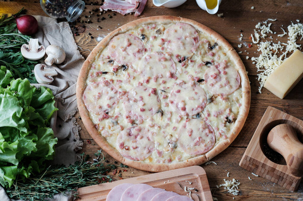pizza with meat and ingredient on the wooden table in rustik style - Фото, изображение